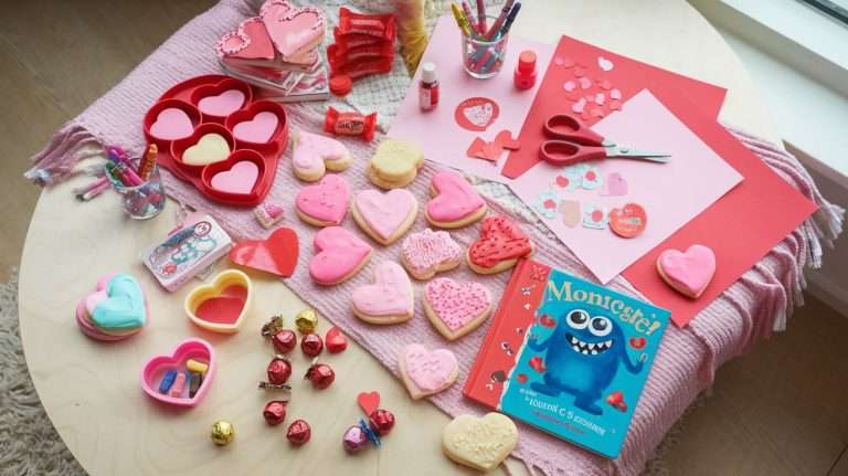 Flat lay of Valentine's Day crafts and treats, including heart-shaped cookies, colorful crayons, and craft supplies.
